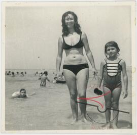 Woman and a young girl posing for a photo at the beach