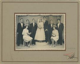 A mounted picture of Karmenu posing with a bride and groom and other people for a wedding picture