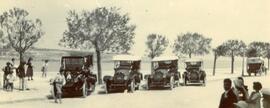 A line-up of four motor-cars with a fifth travelling away