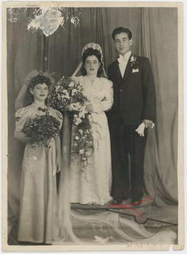 Karmenu and his wife Guza posing for their wedding photo with a bridesmaid