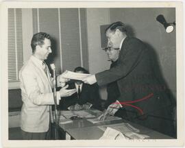 Karmenu receiving a certificate