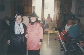 Elderly women dressed in costumes for a party, possibly including Gruppetta's mother