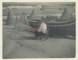 Fisherman mending fishing traps at Marsaxlokk