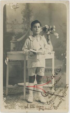 karmenu wearing a Holy Communion outfit posing for a picture in a photographic studio