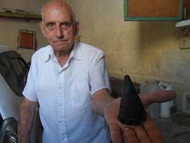 Ċensinu holding the cap of a wartime shell