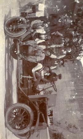 8 men and a boy on a bare vehicle chassis