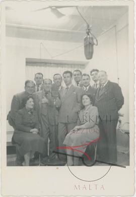 Karmenu surrounded by people in a recording studio