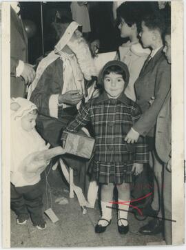 Children receiving gifts from a man dressed as Father Christmas